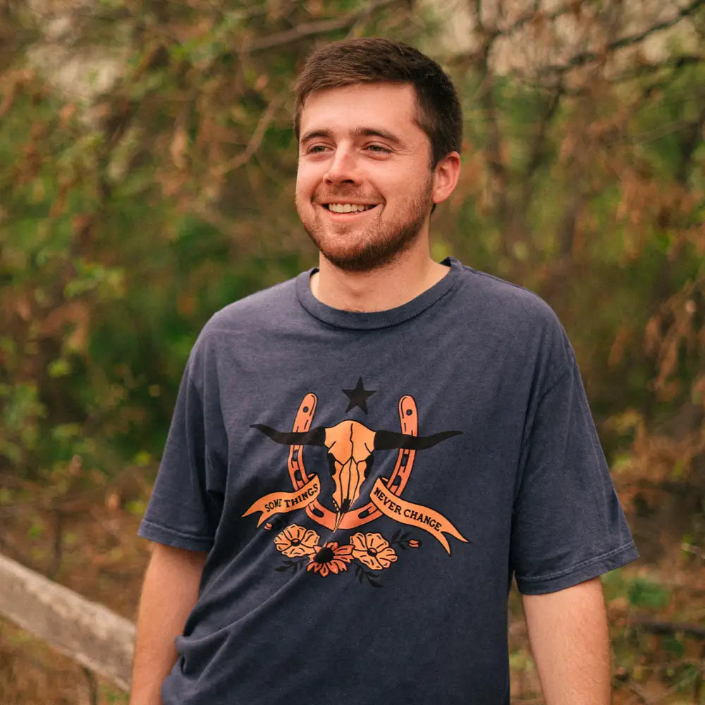Smiling young man wearing a navy t-shirt with an orange graphic design.