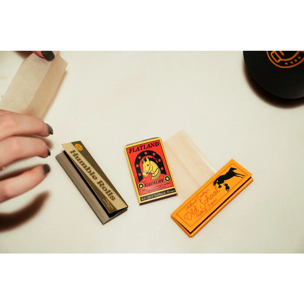 Collection of vintage matchboxes and a matchbook on a light surface.