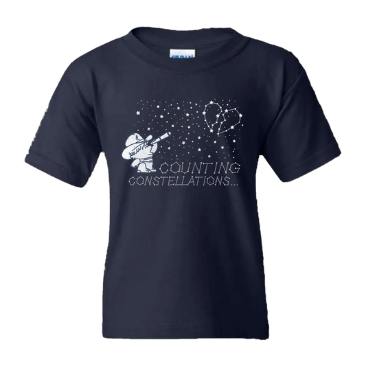 Navy blue kids’ t-shirt featuring a white graphic of a cartoon figure with a telescope pointing at a heart-shaped constellation, accompanied by the text ’counting constellations...’.